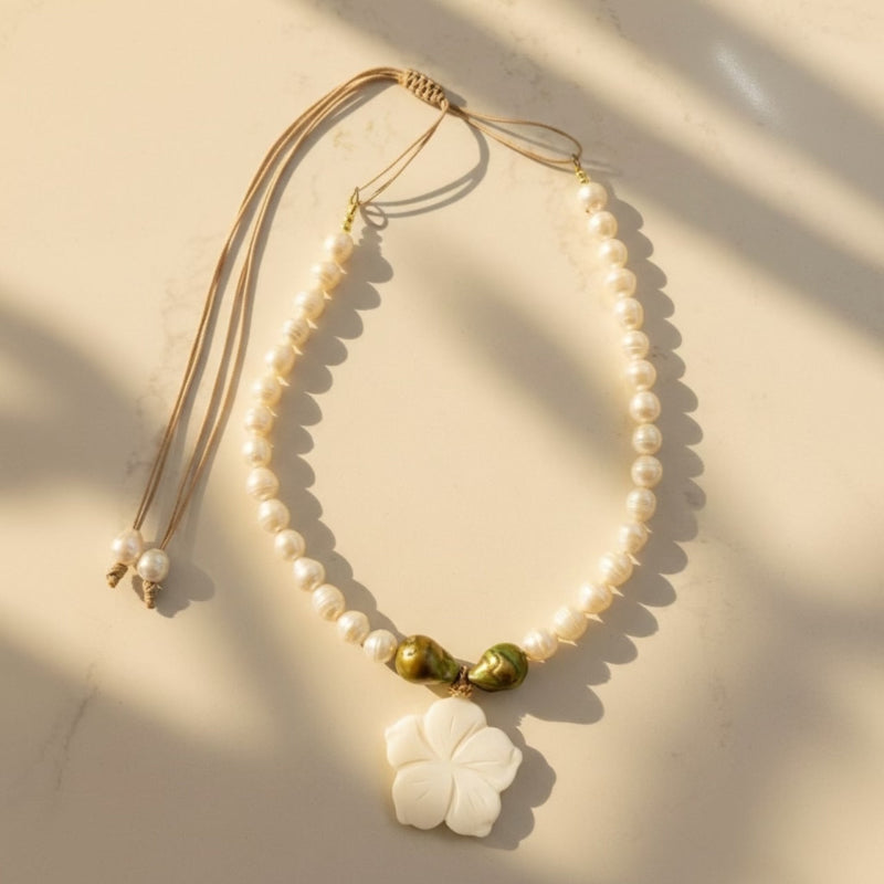 Isla Pearls: Limited quantities nylon adjustable necklace with freshwater pearls and two baroque emerald-lime pearls surrounding a small nacre hibiscus pendant.