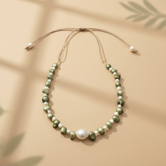 Isla Pearls: Limited quantities nylon adjustable necklace with green baroque pearls and freshwater pearls surrounding a white baroque pearl.
