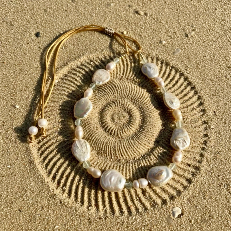 Bask in the gentle warmth of the Sun-Kissed Glow necklace, where the soft peach baroque coin pearls meet luminous peach freshwater pearls and sparkling clear quartz beads.