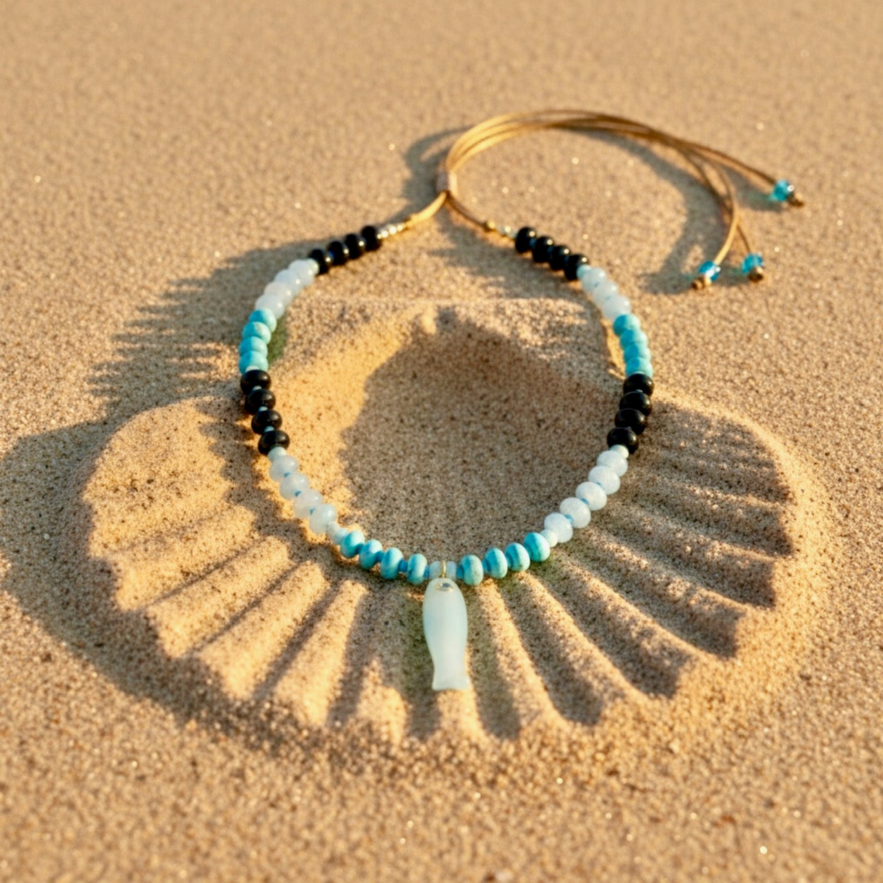 Marina Blue Fish adjustable necklace features dark blue, light blue, and turquoise rondelle beads
