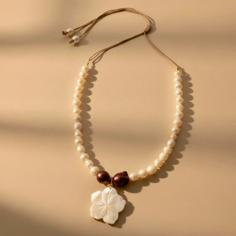 Isla Pearls: Limited quantities nylon adjustable necklace with freshwater pearls and two baroque copper pearls surrounding a small nacre hibiscus pendant.