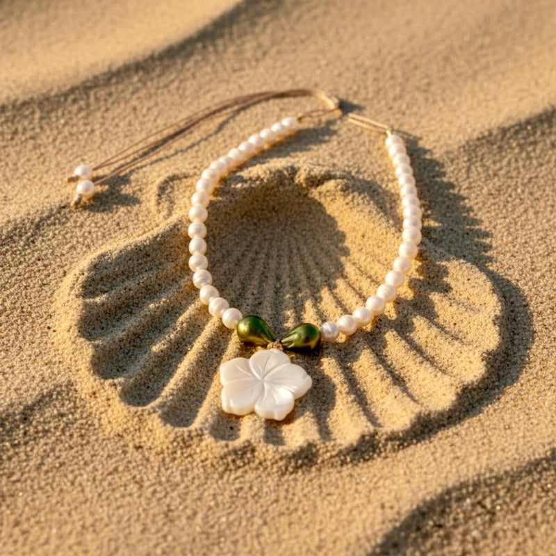 Isla Pearls: Limited quantities nylon adjustable necklace with freshwater pearls and two baroque emerald-lime pearls surrounding a small nacre hibiscus pendant.