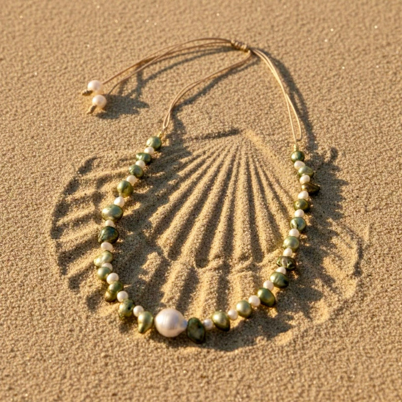 Isla Pearls: Limited quantities nylon adjustable necklace with green baroque pearls and freshwater pearls surrounding a white baroque pearl.