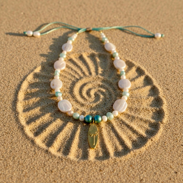 A dance of baroque coin pearls and turquoise and aqua freshwater pearls, crowned with a palm-embossed surfboard stainless steel pendant.