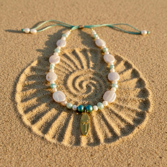A dance of baroque coin pearls and turquoise and aqua freshwater pearls, crowned with a palm-embossed surfboard stainless steel pendant.