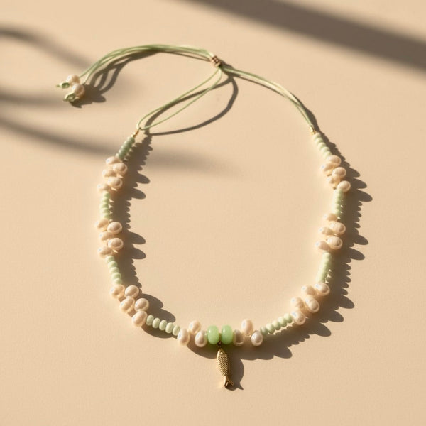 A tranquil, ocean-inspired necklace featuring mint-green shell rondelles and mint-green stones with luminous freshwater pearls. 