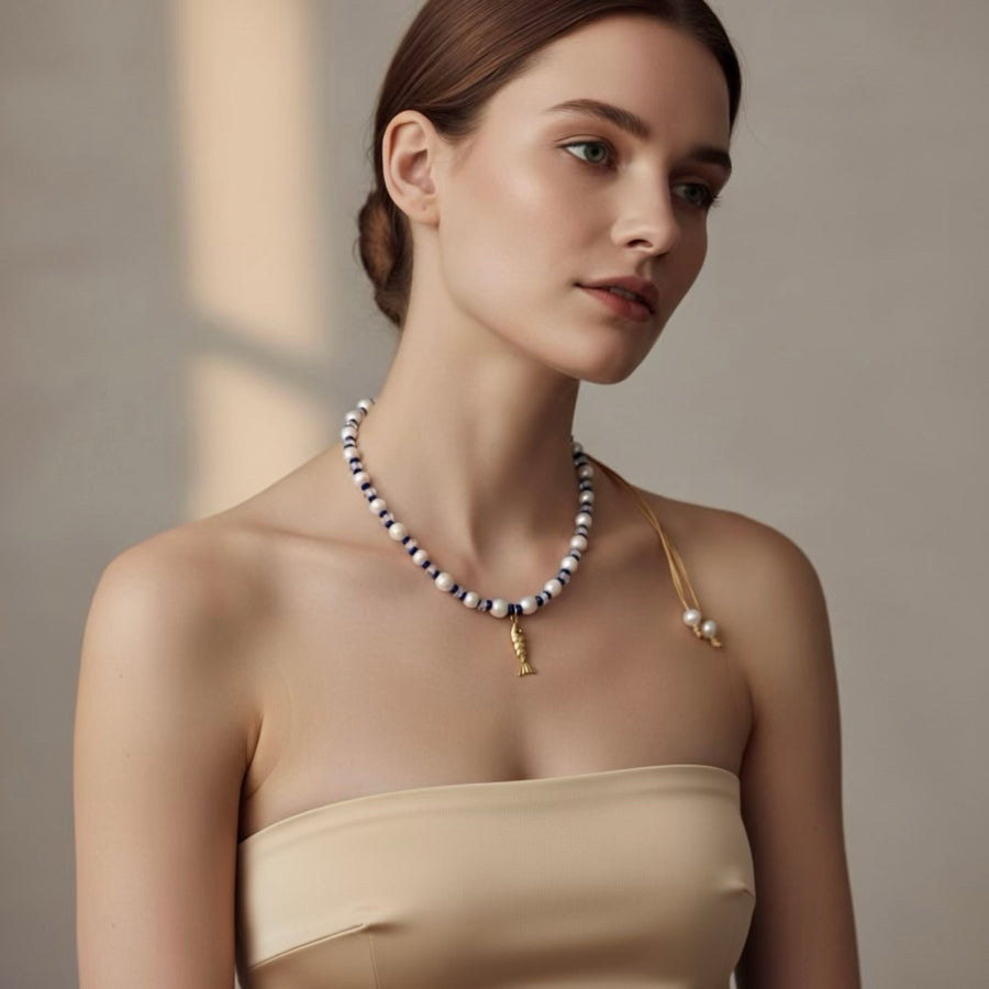 Dive into the Blue Lagoon, a serene blend of freshwater pearls, sparkling clear beads, and vibrant royal blue accents that inspire confidence and tranquility. A stainless steel fish pendant adds a marine touch and represents adaptability and the flow of life.