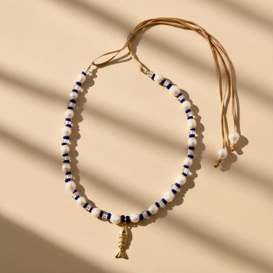 Dive into the Blue Lagoon, a serene blend of freshwater pearls, sparkling clear beads, and vibrant royal blue accents that inspire confidence and tranquility. A stainless steel fish pendant adds a marine touch and represents adaptability and the flow of life.