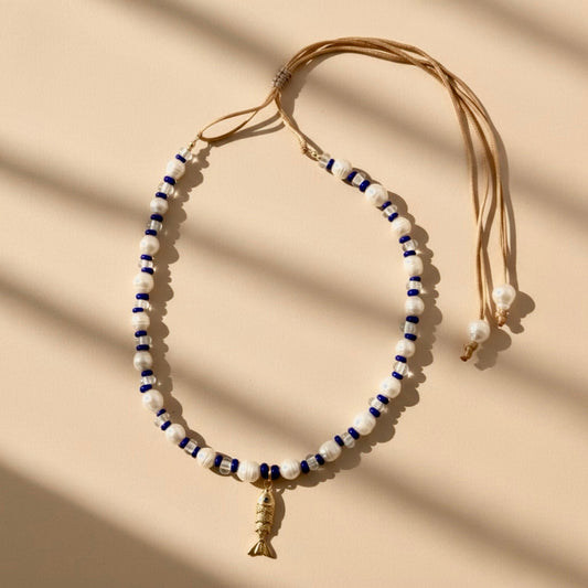 Dive into the Blue Lagoon, a serene blend of freshwater pearls, sparkling clear beads, and vibrant royal blue accents that inspire confidence and tranquility. A stainless steel fish pendant adds a marine touch and represents adaptability and the flow of life.