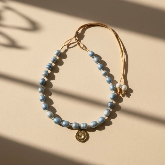 The Blue Moon adjustable necklace captures serenity and hope with blue freshwater pearls - symbols of tranquility and calm - gently linked by warm beige beads that embody balance and connection to the earth. 