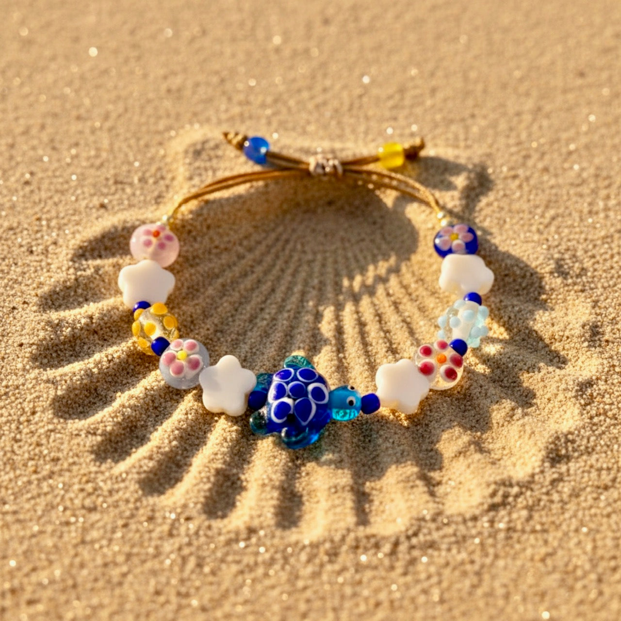 Colorful beaded bracelet with turtle charm on sand