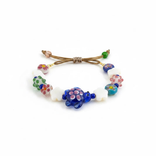 Colorful beaded bracelet with turtle charm on a white background