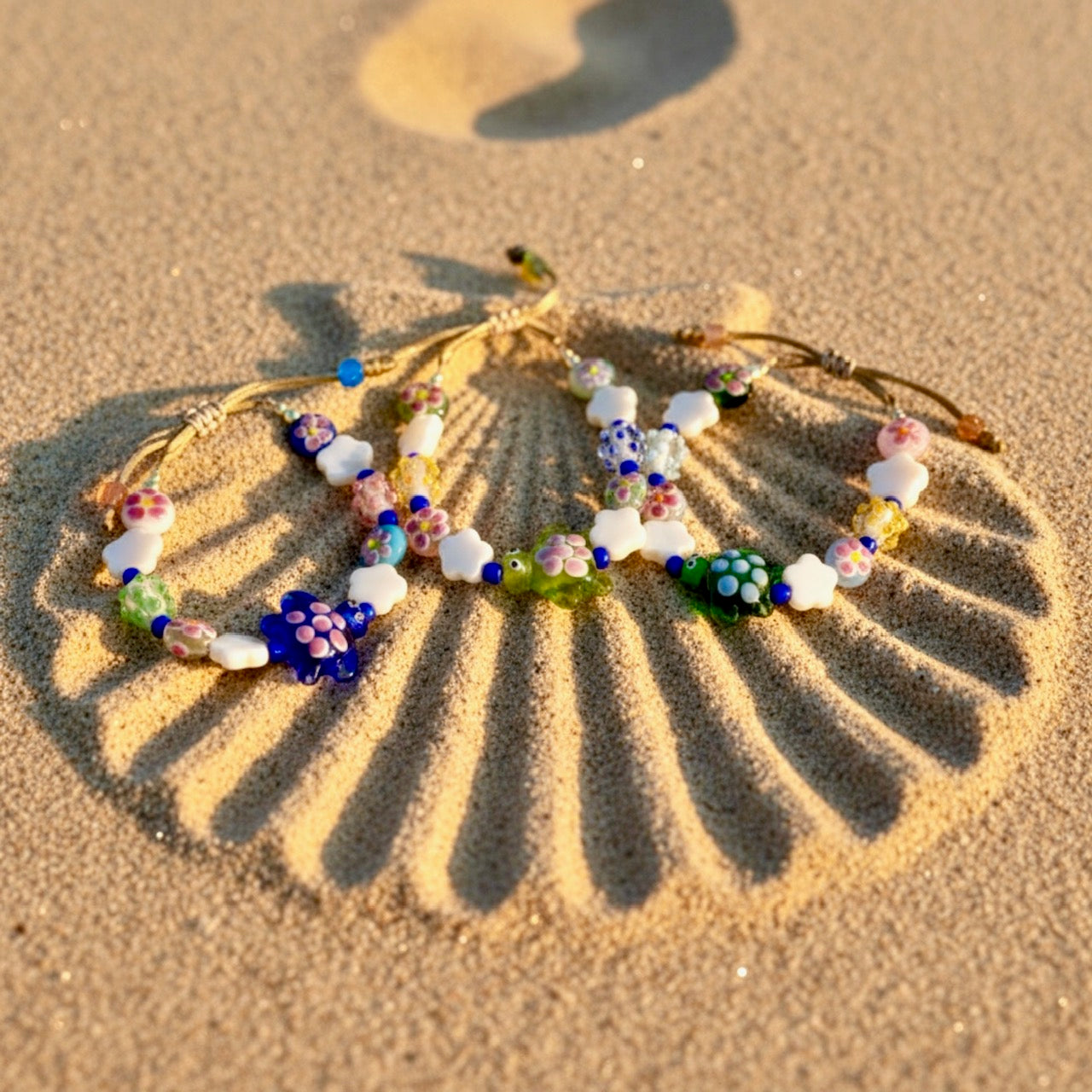 Colorful beaded bracelet on sand with sunlight casting a shadow