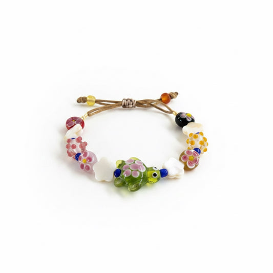 Bracelet with colorful beads and a turtle charm on a white background