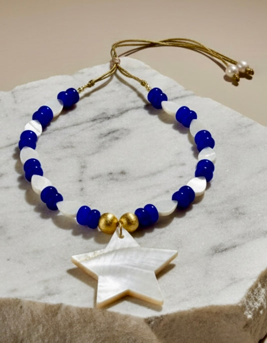 Necklace with blue, white, and gold beads on a marble surface